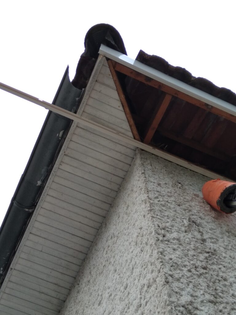 Avancée de toit en bois en mauvais état en cours de dépose
